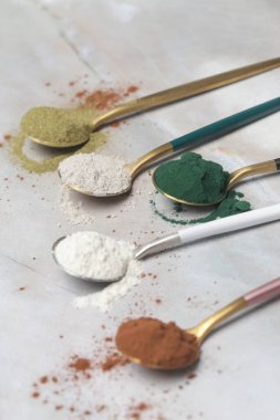 Sağlık ve güzellik için farklı beslenme malzemeleri - kolajen, vitamin, biyotin, kaşıklardaki protein tozu