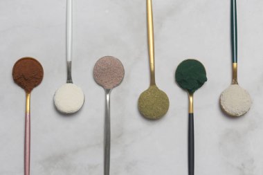 Sağlık ve güzellik için farklı beslenme malzemeleri - kolajen, vitamin, biyotin, kaşıklardaki protein tozu