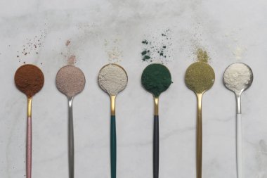 Sağlık ve güzellik için farklı beslenme malzemeleri - kolajen, vitamin, biyotin, kaşıklardaki protein tozu