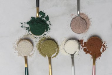 Sağlık ve güzellik için farklı beslenme malzemeleri - kolajen, vitamin, biyotin, kaşıklardaki protein tozu