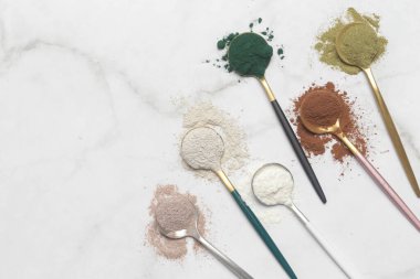 Sağlık ve güzellik için farklı beslenme malzemeleri - kolajen, vitamin, biyotin, kaşıklardaki protein tozu