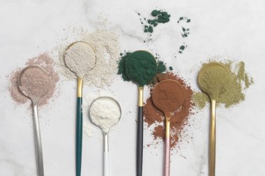 Sağlık ve güzellik için farklı beslenme malzemeleri - kolajen, vitamin, biyotin, kaşıklardaki protein tozu