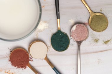 Sağlık ve güzellik için farklı beslenme malzemeleri - kolajen, vitamin, biyotin, kaşıklardaki protein tozu