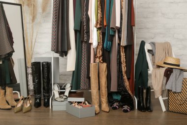 Kadın kıyafetleri ve ayakkabıları. Moda atölyesinde şık ve şık giysilerle elbise askısı. Kaliteli, zamansız moda eserleri.