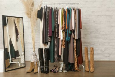 Kadın kıyafetleri ve ayakkabıları. Moda atölyesinde şık ve şık giysilerle elbise askısı. Kaliteli, zamansız moda eserleri.