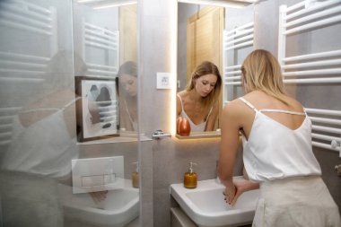 Kadınlar banyo lavabosunda sabun kullanarak ellerini yıkıyor.