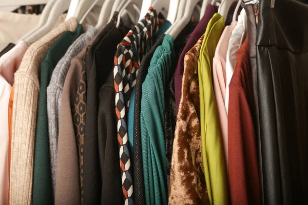 Women\'s fashion. Different clothes on hangers, close up. Huge selection of different used womens clothes on the rack in a second hand shop or thrift store. Concept of waste problem in fashion industry
