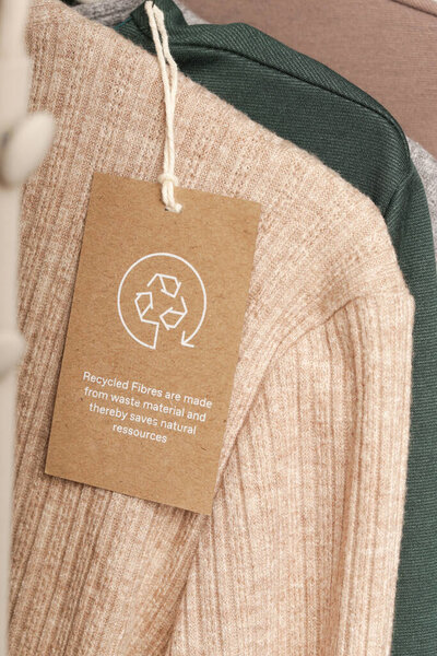 Закрыть ярлык одежды иконой из вторсырья. Концепция вторичной переработки продукции. Отходы, производство самогона, забота об окружающей среде и концепция повторного использования.