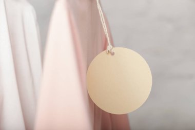 Giyim ürününün fiyat etiketini kapat. Boş yuvarlak etiketli bir kıyafet modeli. Moda endüstrisi ve perakende konsepti.