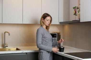 Genç bayan mutfakta bir fincan çayla