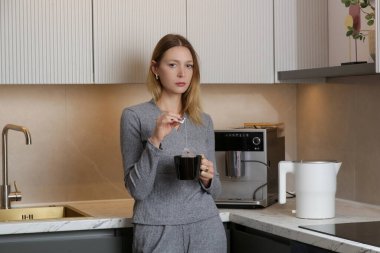 Genç bayan mutfakta bir fincan çayla