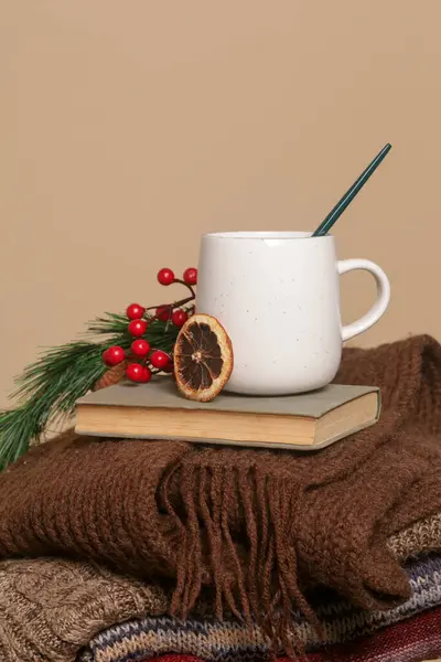 Cozy winter lifestyle concept. Cup of hot drink with vintage book and warm knitted clothes.