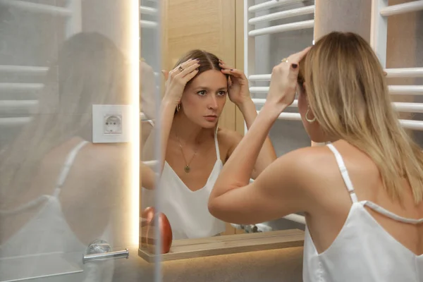 鏡の前で彼女の頭皮と髪を調べる美しい若い女性の肖像画 髪の根 脱毛や乾燥頭皮の問題 — ストック写真