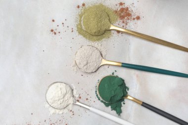 Sağlık ve güzellik için farklı beslenme malzemeleri - kolajen, vitamin, biyotin, kaşıklardaki protein tozu