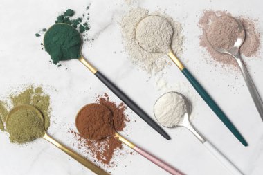 Sağlık ve güzellik için farklı beslenme malzemeleri - kolajen, vitamin, biyotin, kaşıklardaki protein tozu