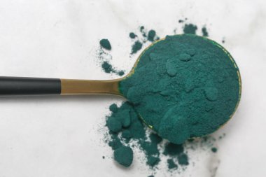 Kaşıkta yeşil toz, spirulina, alage, klorofil veya kibrit. Besin takviyesi, diyet, detoks, önleyici sağlık ve sağlıklı yaşam tarzı kavramı.