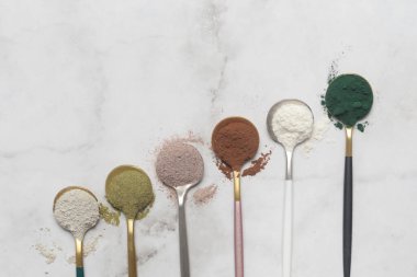 Sağlık ve güzellik için farklı beslenme malzemeleri - kolajen, vitamin, biyotin, kaşıklardaki protein tozu