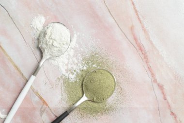 Kaşık içinde yeşil ve beyaz toz. Kolajen, protein, moringa, spirulina, hlorofil, kibrit tozu. Besin takviyesi, diyet, detoks, önleyici sağlık ve sağlıklı yaşam tarzı kavramı.