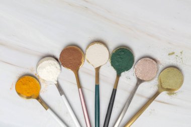 Sağlık ve güzellik için farklı beslenme malzemeleri - kolajen, vitamin, biyotin, kaşıklardaki protein tozu