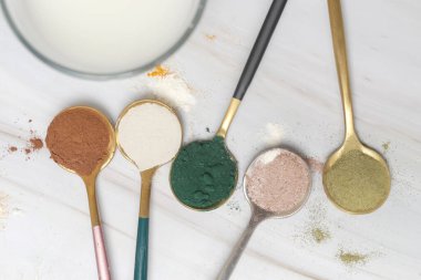 Sağlık ve güzellik için farklı beslenme malzemeleri - kolajen, vitamin, biyotin, kaşıklardaki protein tozu