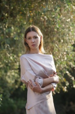 Bej rengi uzun ipek elbise, moda yaz portresi, en az zarif kadın tarzı.