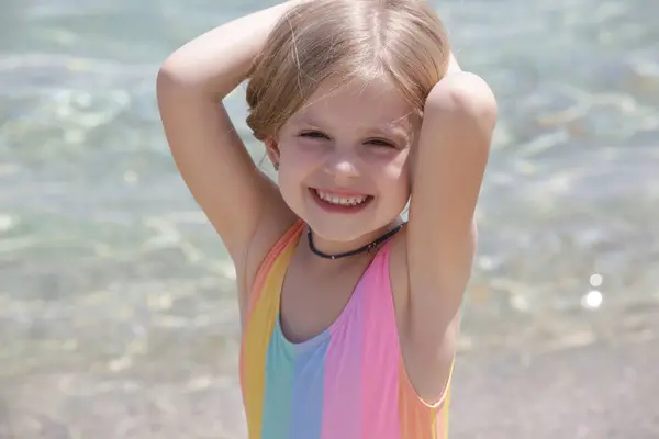 Candid portrait of cheerful little girl on the beach