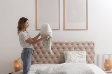 Yatak odasında çarşaf değiştiren kadın, rahat ev hayatı, ev hanımı temizliği, yatak odası düzenleme, ev işi konsepti..