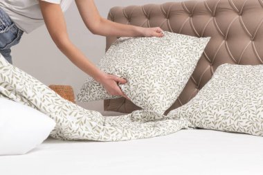 Yatak odasında çarşaf değiştiren kadın, rahat ev hayatı, ev hanımı temizliği, yatak odası düzenleme, ev işi konsepti..