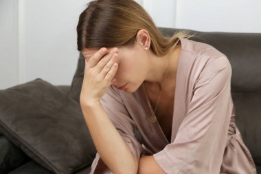 Üzüntüye boğulmuş genç bir kadının portresi başını eğip koltuğa oturdu. Kötü haber, boşanma, ayrılma, yorgunluk, keder, üzüntü, yalnızlık, uykusuzluk, baş ağrısı