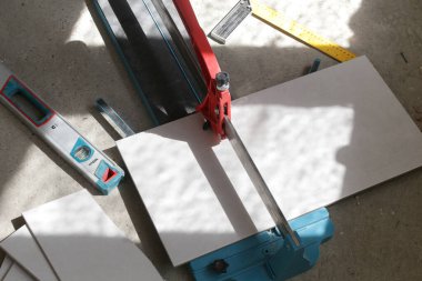 Standart bir fayans kesicisiyle fayanslar kesiliyor. Banyoya fayans döşeme işlemi adım adım yapılıyor. DIY Ev Geliştirme.