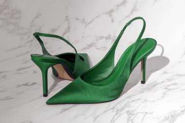 Yeşil saten topukluların yaratıcı stüdyo çekimi. Şık sivri uçlu, ürün fotoğrafçılığı.