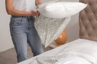 Yatak odasında çarşaf değiştiren kadın, rahat ev hayatı, ev hanımı temizliği, yatak odası düzenleme, ev işi konsepti..