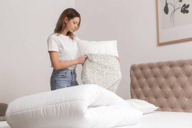 Yatak odasında çarşaf değiştiren kadın, rahat ev hayatı, ev hanımı temizliği, yatak odası düzenleme, ev işi konsepti..