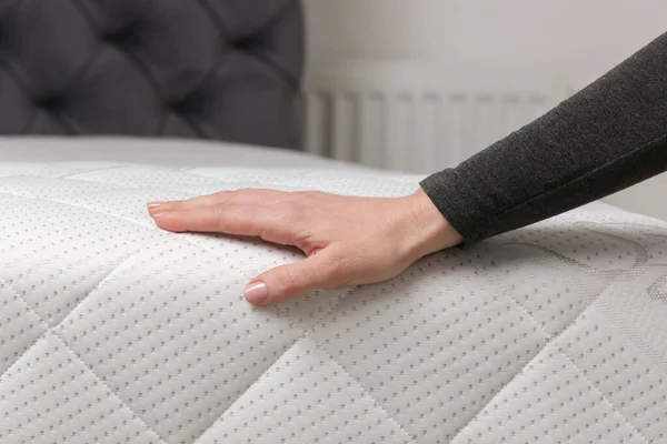 Woman press on comfortable mattress, checking and testing quality