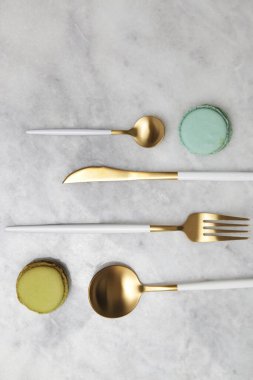 Mermer masadaki altın çatal bıçakların yaratıcı çekimi, tasarım konsepti. Modern mutfak. İskandinav tarzı sofra takımı.