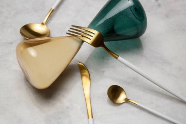 Mermer masadaki altın çatal bıçakların yaratıcı çekimi, tasarım konsepti. Modern mutfak. İskandinav tarzı sofra takımı.