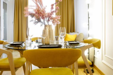 Dining table in the kitchen with pink flowers bouquet in the vase