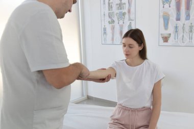 Doktorun muayenehanesindeki kadın kas ve kas gerilimini azaltmak, kas ve kas sorunlarını tedavi etmek ve önlemek için kayropraktik, fizyoterapi veya miyodinamik tedavi uyguluyor..