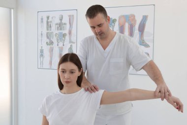 Doktorun muayenehanesindeki kadın kas ve kas gerilimini azaltmak, kas ve kas sorunlarını tedavi etmek ve önlemek için kayropraktik, fizyoterapi veya miyodinamik tedavi uyguluyor..