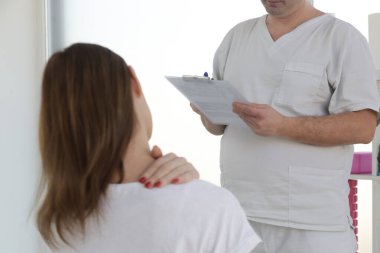 Doktorun muayenehanesindeki kadın kas ve kas gerilimini azaltmak, kas ve kas sorunlarını tedavi etmek ve önlemek için kayropraktik, fizyoterapi veya miyodinamik tedavi uyguluyor..