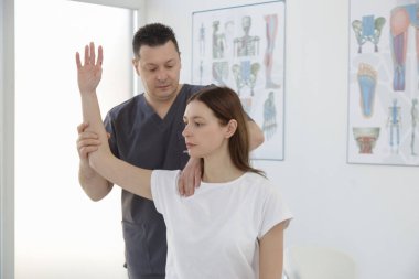 Doktorun muayenehanesindeki kadın kas ve kas gerilimini azaltmak, kas ve kas sorunlarını tedavi etmek ve önlemek için kayropraktik, fizyoterapi veya miyodinamik tedavi uyguluyor..