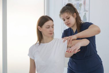 Doktorun muayenehanesindeki kadın kas ve kas gerilimini azaltmak, kas ve kas sorunlarını tedavi etmek ve önlemek için kayropraktik, fizyoterapi veya miyodinamik tedavi uyguluyor..