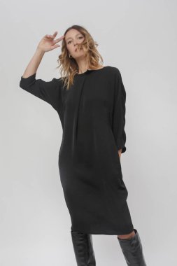 Stüdyoda çekilmiş siyah elbiseli genç bir modelin fotoğrafları.