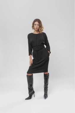 Stüdyoda çekilmiş siyah elbiseli genç bir modelin fotoğrafları.