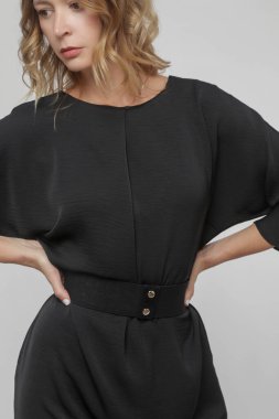 Stüdyoda çekilmiş siyah elbiseli genç bir modelin fotoğrafları.