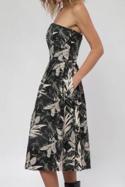 Straplez bluzlu kadın modelin seri fotoğrafları. Tropikal siyah çiçekli parlak etekli midi elbisesi.