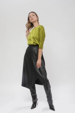 Stüdyo fotoğrafları, ipek yeşil bluz ve siyah deri etek giyen kadın modeller.