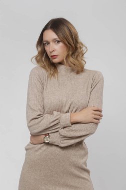 Stüdyo fotoğrafları, örgü bej bir elbise giymiş kadın model, sonbahar kış moda koleksiyonu..