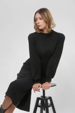 Stüdyo fotoğrafları, örgü siyah Midi elbisesi giymiş kadın model, sonbahar kış moda koleksiyonu.