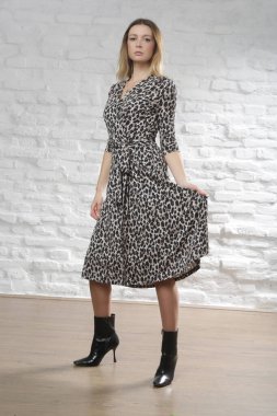 Serie of studio photos of young female model in animal print wrap dress, autumn winter fashion collection.